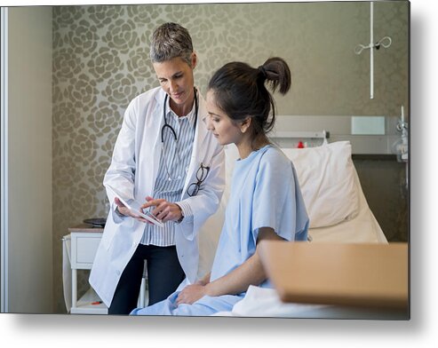 Mature Adult Metal Print featuring the photograph Female doctor showing digital tablet to patient by Stígur Már Karlsson /Heimsmyndir