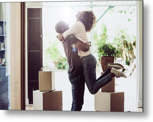 Young Men Metal Print featuring the photograph Happy man lifting woman in new house by Portra
