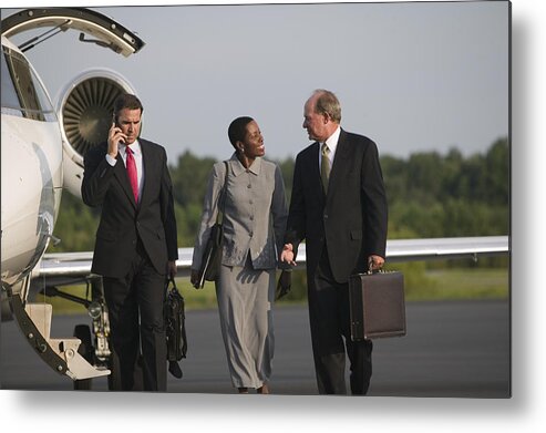 Three Quarter Length Metal Print featuring the photograph Men and woman talking near airplane by Comstock Images