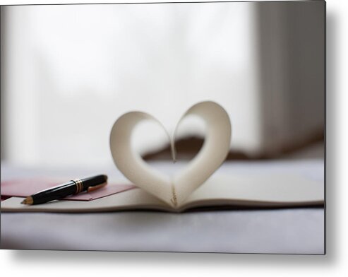 Holiday Metal Print featuring the photograph Pen and pages of notebook forming heart-shape by Tom Merton