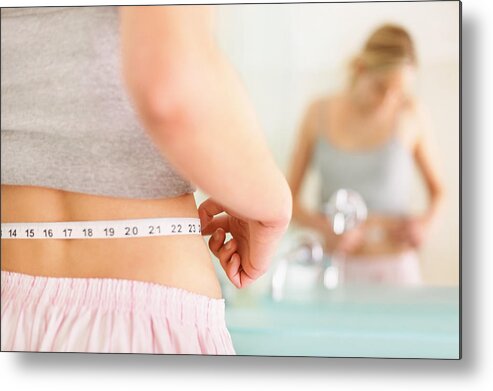 People Metal Print featuring the photograph Rear view of woman measuring waist with mirror reflection by GlobalStock