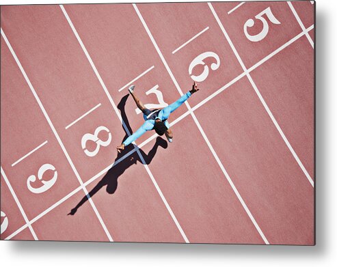 Shadow Metal Print featuring the photograph Runner crossing finishing line on track by Paul Bradbury