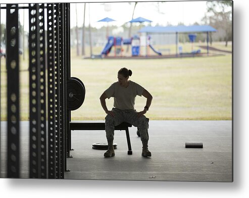 Working Metal Print featuring the photograph Silhouetted female soldier barbell training at air force military base by Sean Murphy