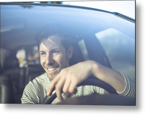 Young Men Metal Print featuring the photograph Smiling young man driving car by Westend61