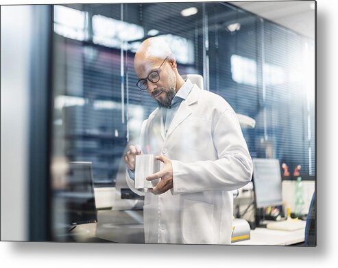 Expertise Metal Print featuring the photograph Technician wearing lab coat examining workpiece by Westend61