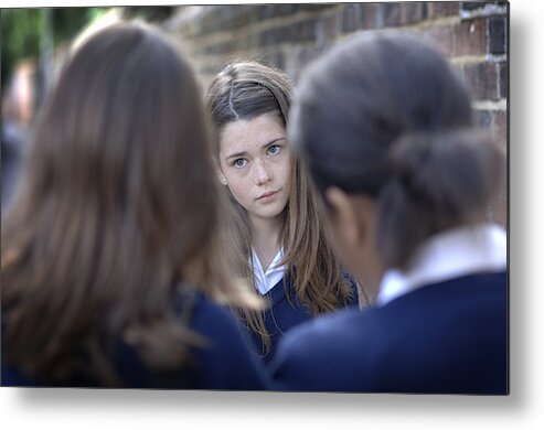 People Metal Print featuring the photograph Two girls (12-13) bullying other school girl (10-11), differential focus by Chris Whitehead