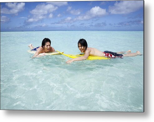 25-29 Years Metal Print featuring the photograph Two Young Men Lie on Surfboards in the Sea, Laughing by Dex