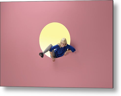 Copenhagen Metal Print featuring the photograph Woman crawling out of round opening in coloured wall by Klaus Vedfelt