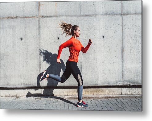 Mid Adult Women Metal Print featuring the photograph Woman running outdoors in the city by Nikada