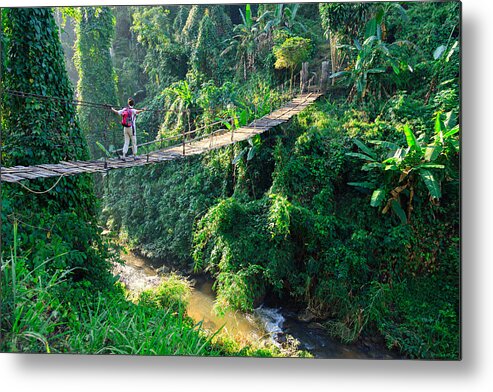 Tropical Rainforest Metal Print featuring the photograph Woman with backpack on suspension bridge in rainforest by FredFroese