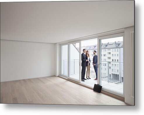Expertise Metal Print featuring the photograph Young couple viewing flat with estate agent by Westend61