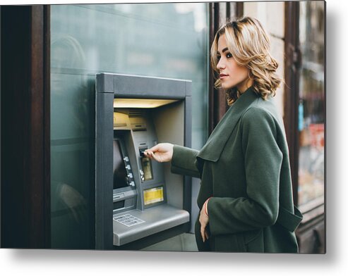 Coin Metal Print featuring the photograph Young woman using ATM by Eclipse_images