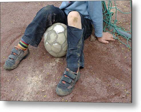 Ball Metal Print featuring the photograph Boy with soccer ball sitting on dirty field by Matthias Hauser