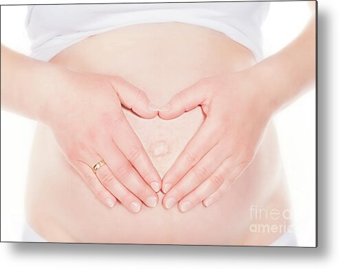 Pregnant Metal Print featuring the photograph Pregnant woman touching her belly, forming a heart shape. by Michal Bednarek