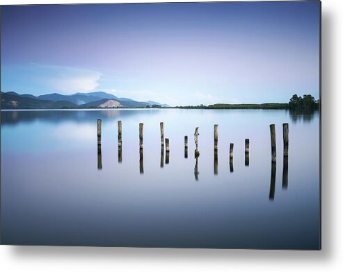 Lake Metal Print featuring the photograph Wooden pier or jetty remains on a blue lake sunset and sky refle #3 by Stefano Orazzini