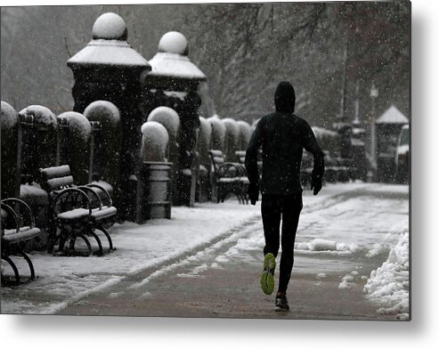 Cold Metal Print featuring the photograph A Man Jogs During a Snowstorm in Upper by Mike Segar