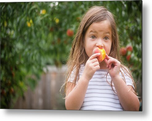 Girl Metal Print featuring the photograph Cute Girl Eating Fresh Organic Peach While Standing At Farm by Cavan Images