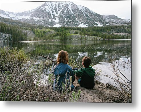 Siblings Metal Print featuring the photograph Rear View Of Siblings Looking At View While Sitting By Lake At Inyo National Forest by Cavan Images