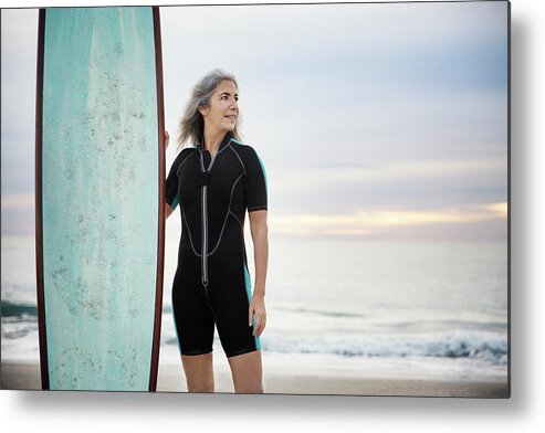 Smiling Metal Print featuring the photograph Smiling Female Surfer Looking Away While Holding Surfboard At Delray Beach During Sunset by Cavan Images