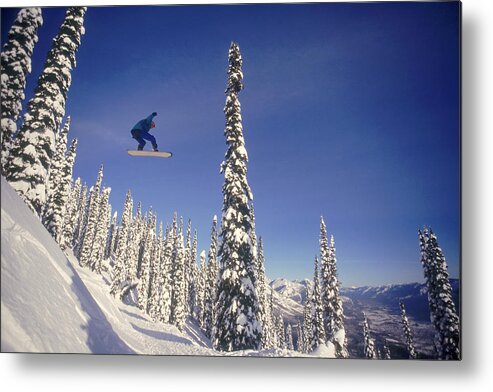 People Metal Print featuring the photograph Snowboarding Jumping Through Air by Comstock