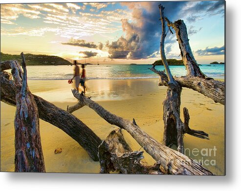 Atlantic Ocean Metal Print featuring the photograph Couple walking along a sandy beach at sunset. #1 by Don Landwehrle