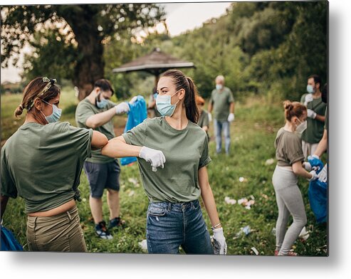 Working Metal Print featuring the photograph Group of volunteers with surgical masks cleaning nature together by South_agency