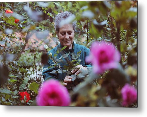 Working Metal Print featuring the photograph Woman with flowers in the garden #1 by Tolgart