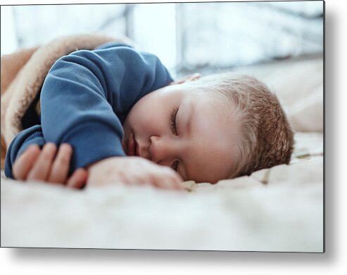 Playroom Metal Print featuring the photograph An adorable two years baby boy taking a nap by Pyrosky