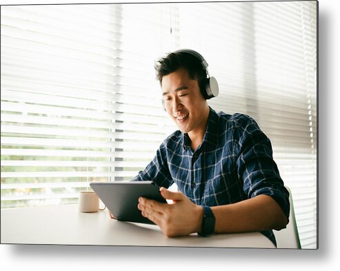 People Metal Print featuring the photograph An Asian man relaxing by the home window and typing a message on his digital tablet by KSChong