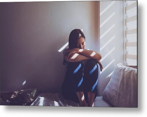 Problems Metal Print featuring the photograph Asian women are sitting hugging their knees in bed. Feeling sad, disappointed in love In the dark bedroom and sunlight from the window through the blinds.Vintage tone. by Bunditinay