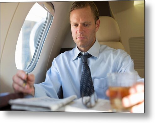 People Metal Print featuring the photograph Businessman doing crossword on airplane by Image Source/InStock
