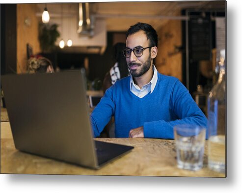 Working Metal Print featuring the photograph Businessman using laptop in cafe by Compassionate Eye Foundation