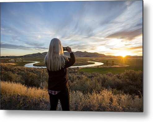 Tranquility Metal Print featuring the photograph Caucasian woman photographing sunset over winding river by Steve Smith