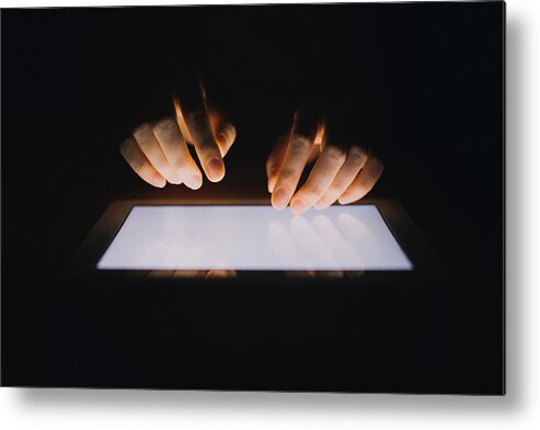 Using Digital Tablet Metal Print featuring the photograph Close up of human hands typing on digital tablet against black background by D3sign