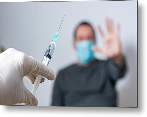 Mid Adult Metal Print featuring the photograph Close up of unrecognizable doctor trying to vaccinate its patient while he is refusing it by StockPlanets