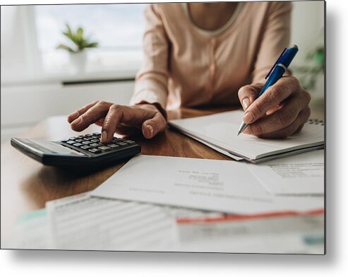 Debt Metal Print featuring the photograph Close up of woman planning home budget and using calculator. by Skynesher