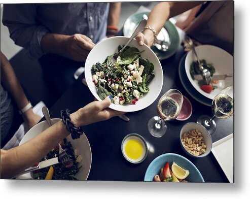 55-59 Years Metal Print featuring the photograph Cropped image of friends holding salad bowl at table by Maskot