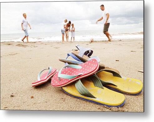 Mid Adult Women Metal Print featuring the photograph Family on beach, flip-flops in foreground by Peter Cade