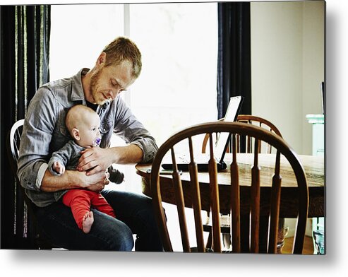 People Metal Print featuring the photograph Father holding baby girl on lap at dining table by Thomas Barwick