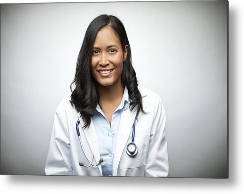 Expertise Metal Print featuring the photograph Female doctor smiling over white background by Morsa Images