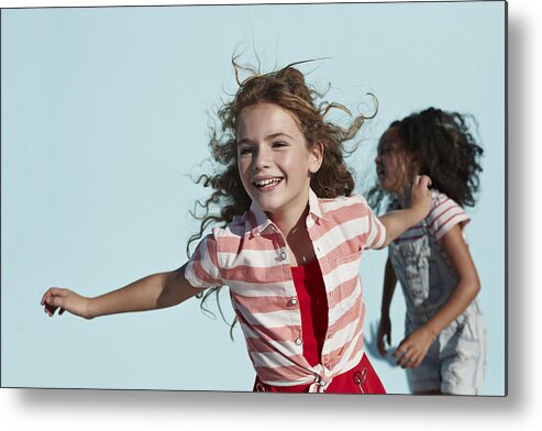 Child Metal Print featuring the photograph Girl running with arms out, on studio background by Klaus Vedfelt