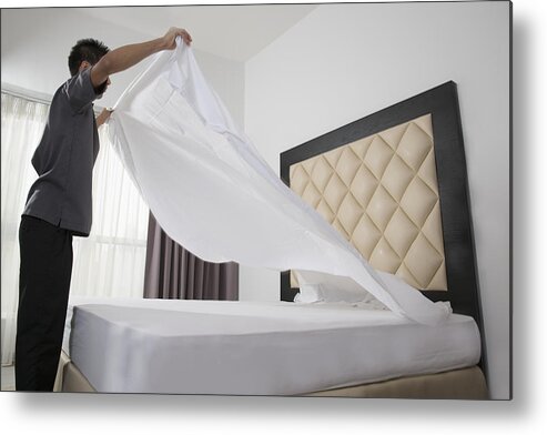 Working Metal Print featuring the photograph Male Housekeeper In Hotel Throwing Sheet On Bed by Gary John Norman