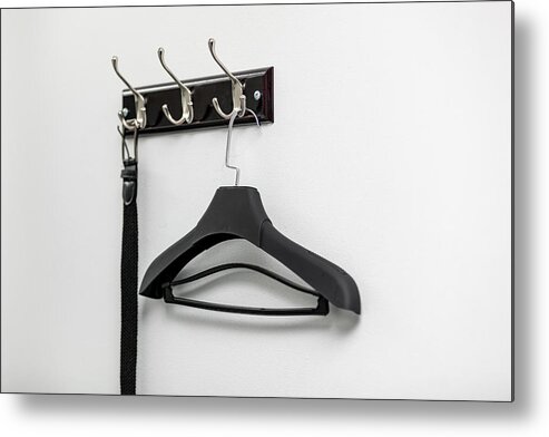 Lifestyles Metal Print featuring the photograph Male leather belt on hanger on hooks. by Shcherbak Volodymyr