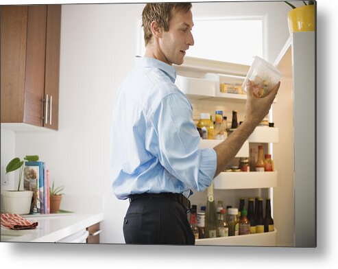 People Metal Print featuring the photograph Man looking at leftovers in refrigerator by Jupiterimages