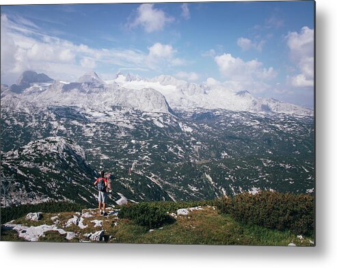 Sportive Metal Print featuring the photograph Man with a backpack looks at the Dachstein massif by Vaclav Sonnek