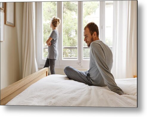 Mid Adult Men Metal Print featuring the photograph Mid adult couple in bedroom, having disagreement by Kris Ubach and Quim Roser