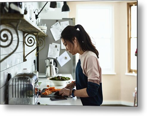 Asian And Indian Ethnicities Metal Print featuring the photograph Mid adult Korean woman chopping vegetables on kitchen counter by 10'000 Hours