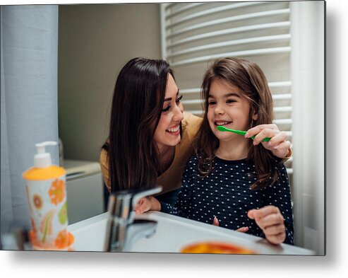 Toothbrush Metal Print featuring the photograph Mother and daughter brushing teeth by RgStudio