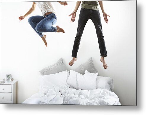 Young Men Metal Print featuring the photograph Portrait of couple jumping on bed by Flashpop