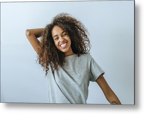Cool Attitude Metal Print featuring the photograph Portrait of woman with afro hair smiling with white wall background by F.J. Jimenez